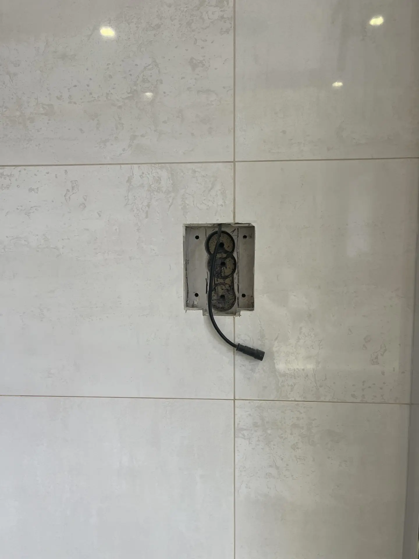 Existing backbox and data cable revealed behind an old digital shower control