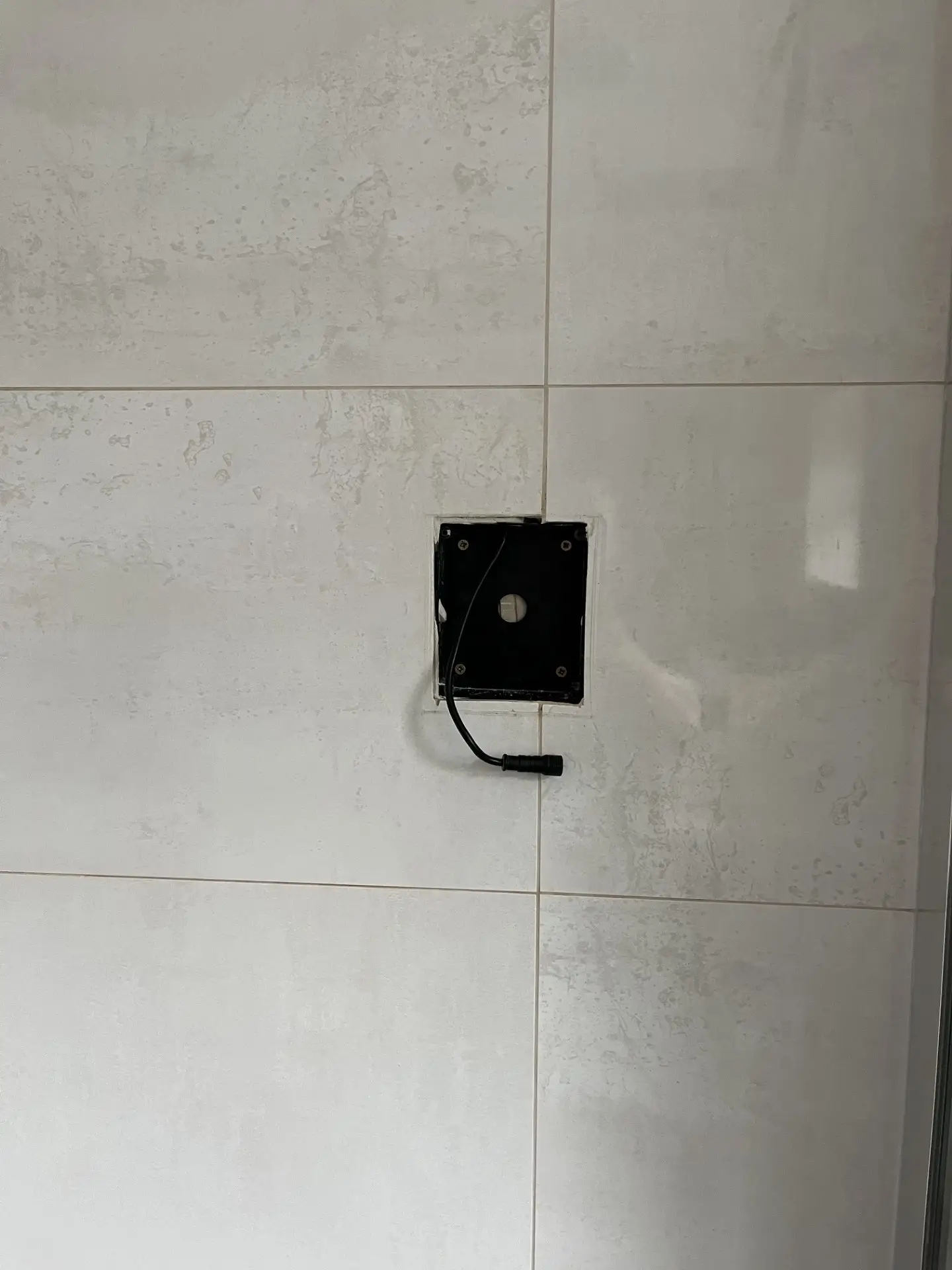 Hole left in a tiled wall after removing an old digital shower control